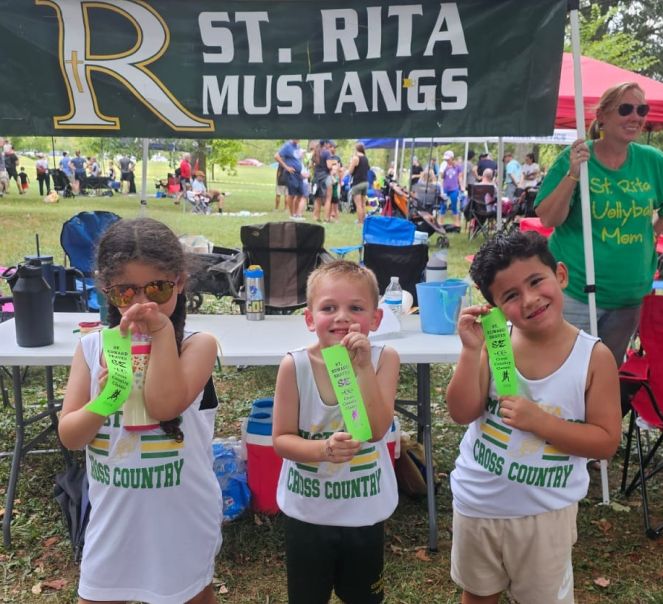 Saint Rita Cross Country runners holding up awards
